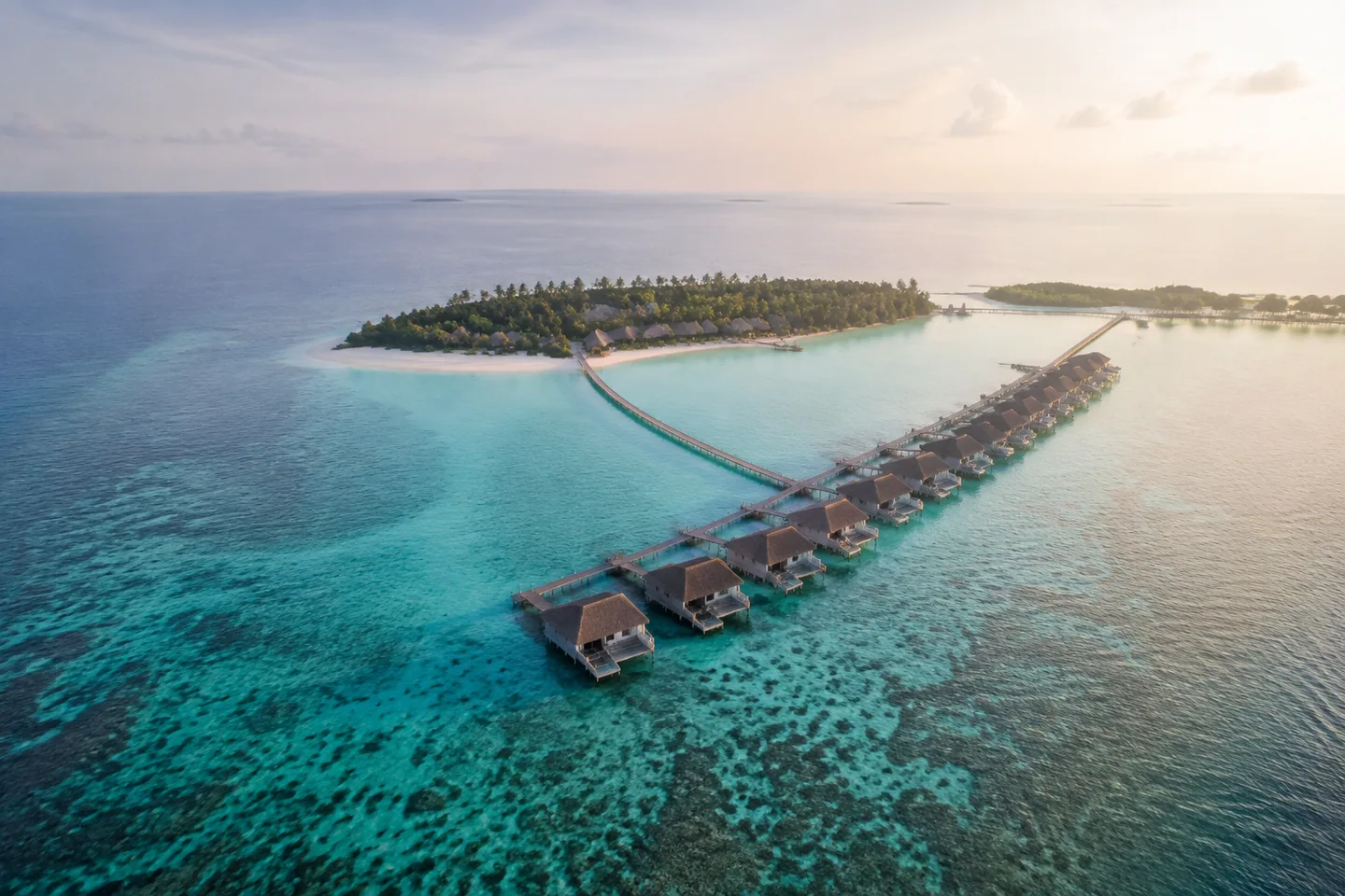 A small island resort and overwater villas surrounded by clear turquoise water